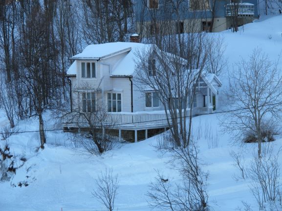 Ein verschneites Haus an der Küste